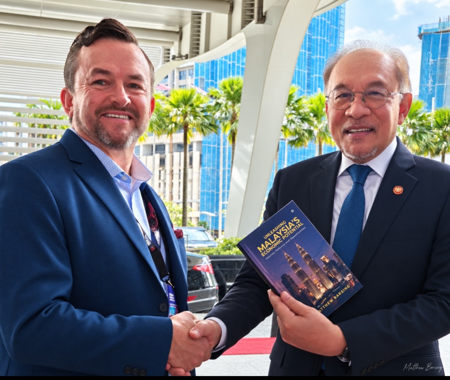 Matthew Barsing presenting his book to Malaysia’s Prime Minister